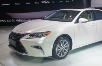 White Lexus hybrid car displayed in a showroom setting, showcasing sleek design and advanced hybrid technology.