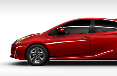 Red Toyota Prius Hybrid shown in profile view, highlighting its aerodynamic design and eco-friendly hybrid technology.